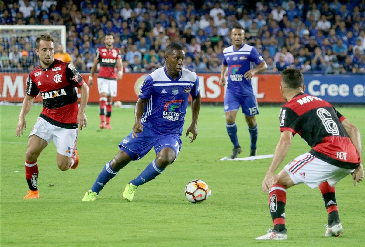 Jogadores do Flamengo e Emelec disputam uma jogada no gramado